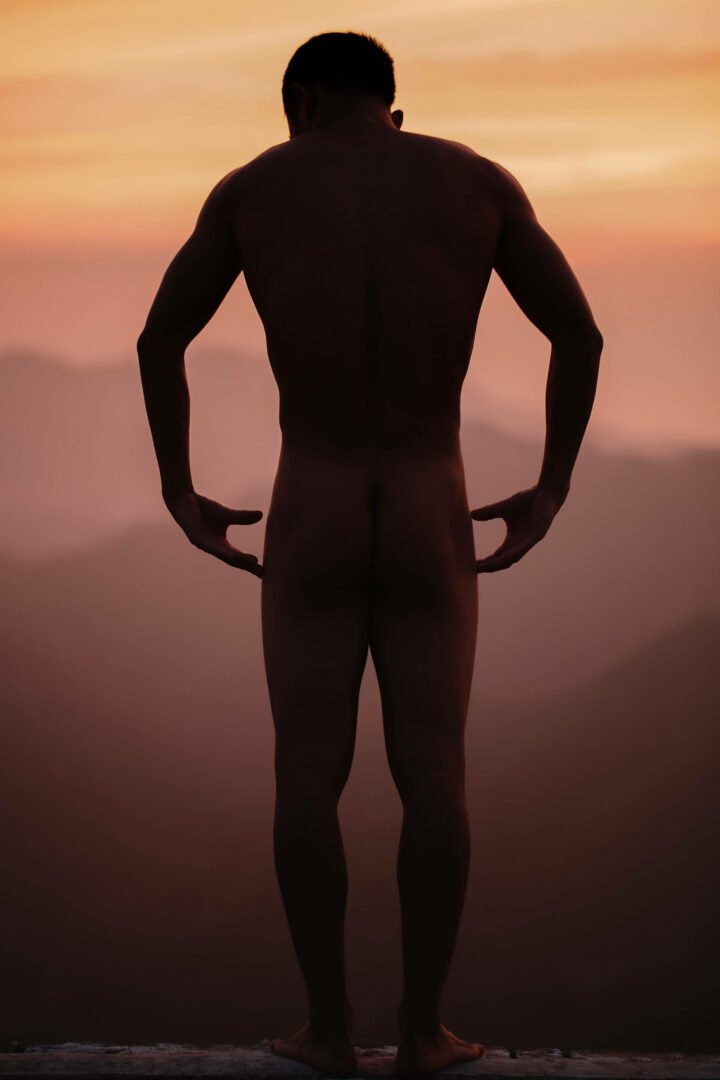 Sexual Man standing nude on the Great Wall in China while the sun was setting and the skies were burning.