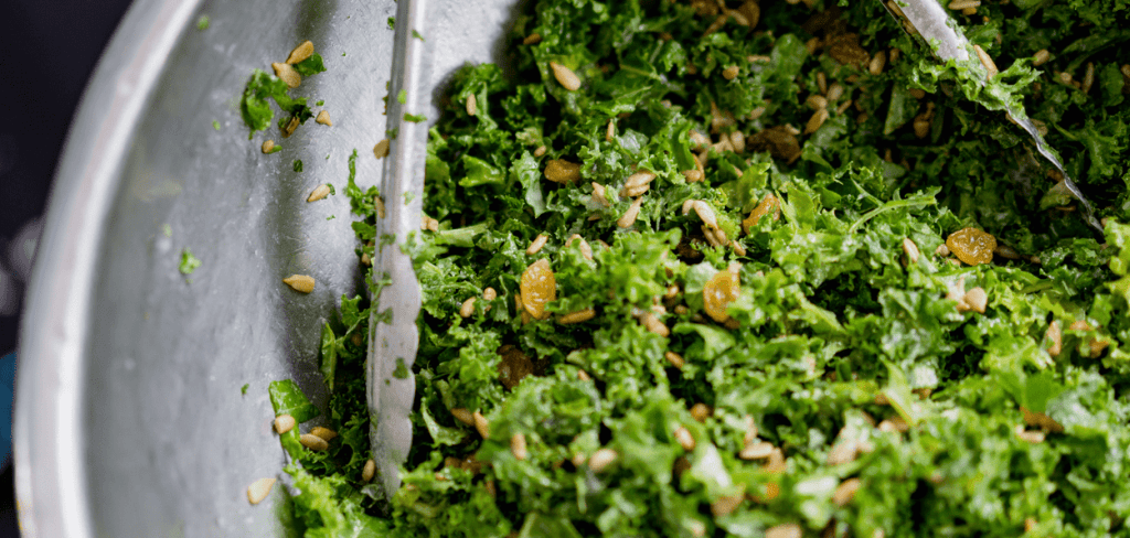 A salad bowl filled with Kale and Sun Raisins