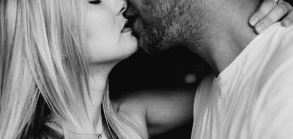 A man woman embracing in a sensual kiss