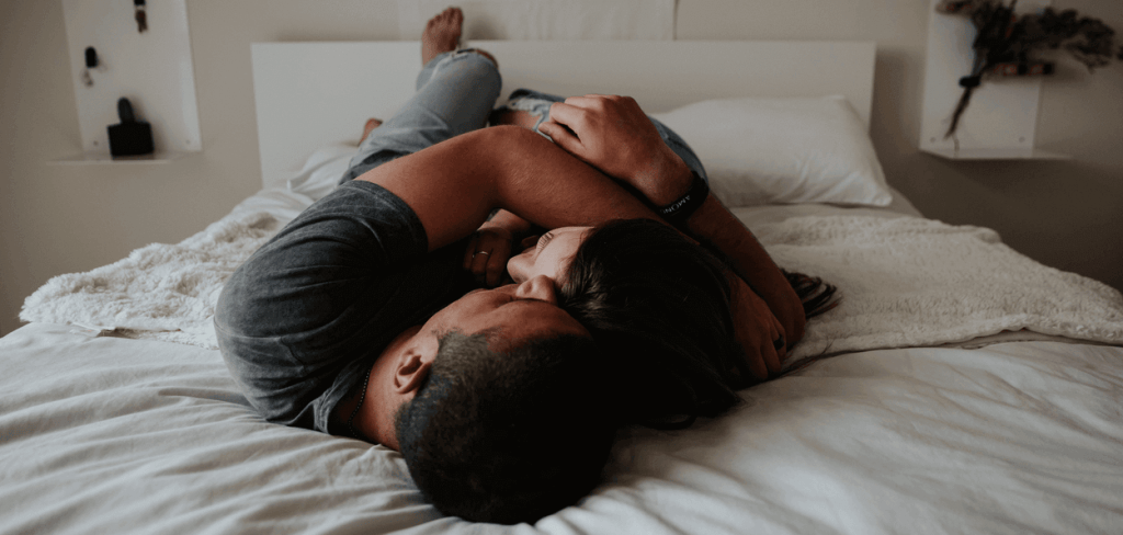 Loving Couple Hugging Tightly in Bed Facing One Another