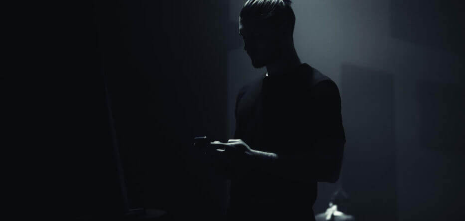 man wearing black t-shirt on his cell phone