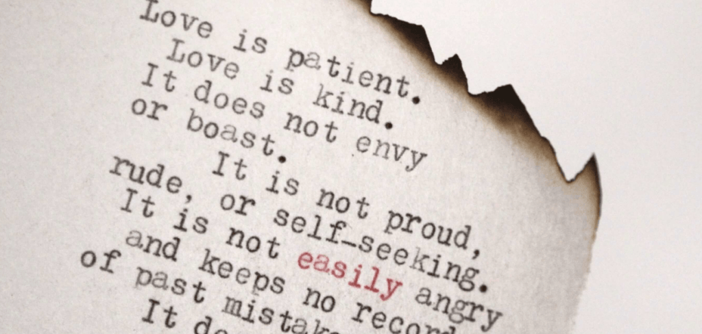 Love is Patient, Love is Kind Printed on a Burned Piece of Paper