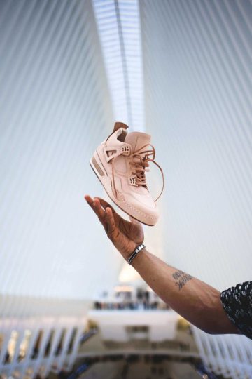 A man at new york city's oculus tossing a sneakers in the air.