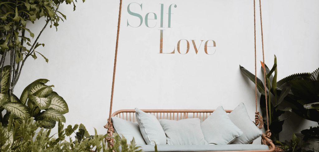 Self-Love Writing on a Wall in Front of a Large Swing