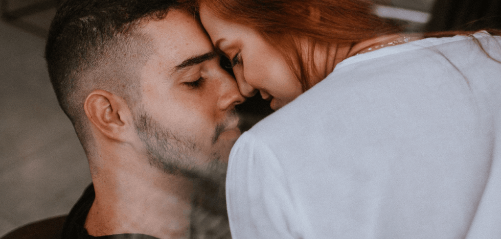 a man and woman nose to nose smiling at one another