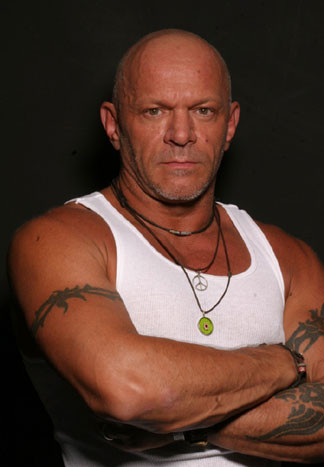 Photo of Junior Vasquez in a white tank top with his hands folded.