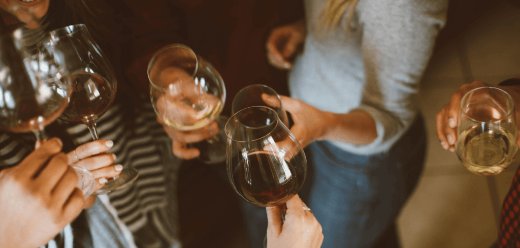 a group of hipsters tossing wine glasses