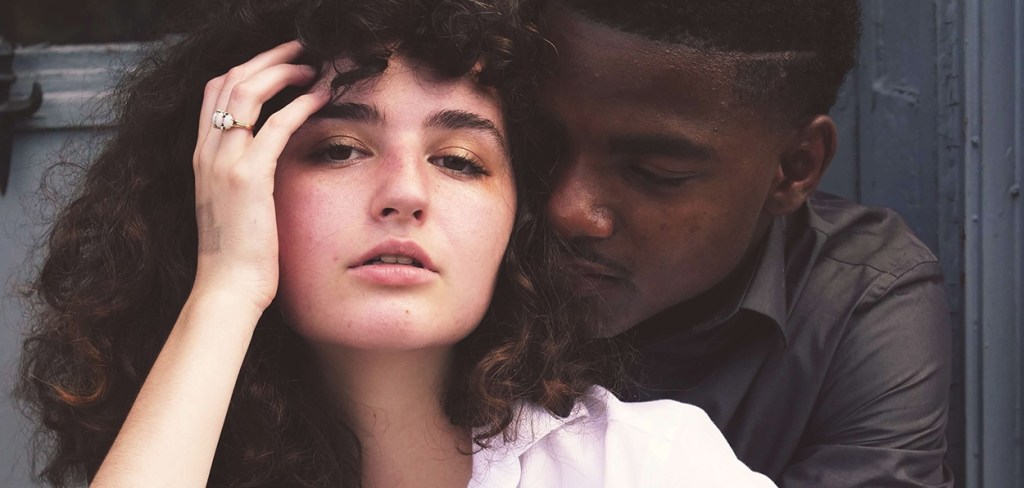 A black and white couple cozy on the stoop in NYC