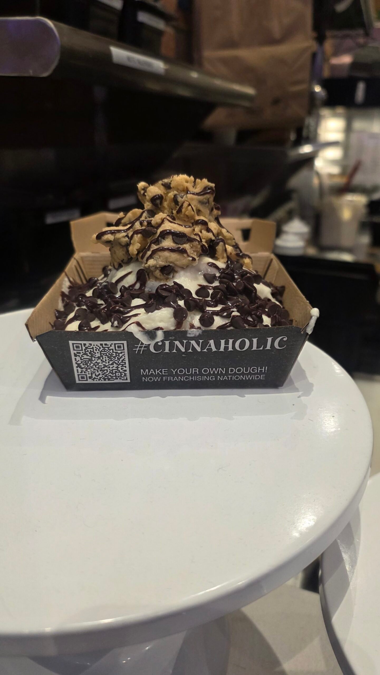 Cookie Monster cinnamon roll from Cinnaholic with cookie dough, chocolate chips, and chocolate drizzle