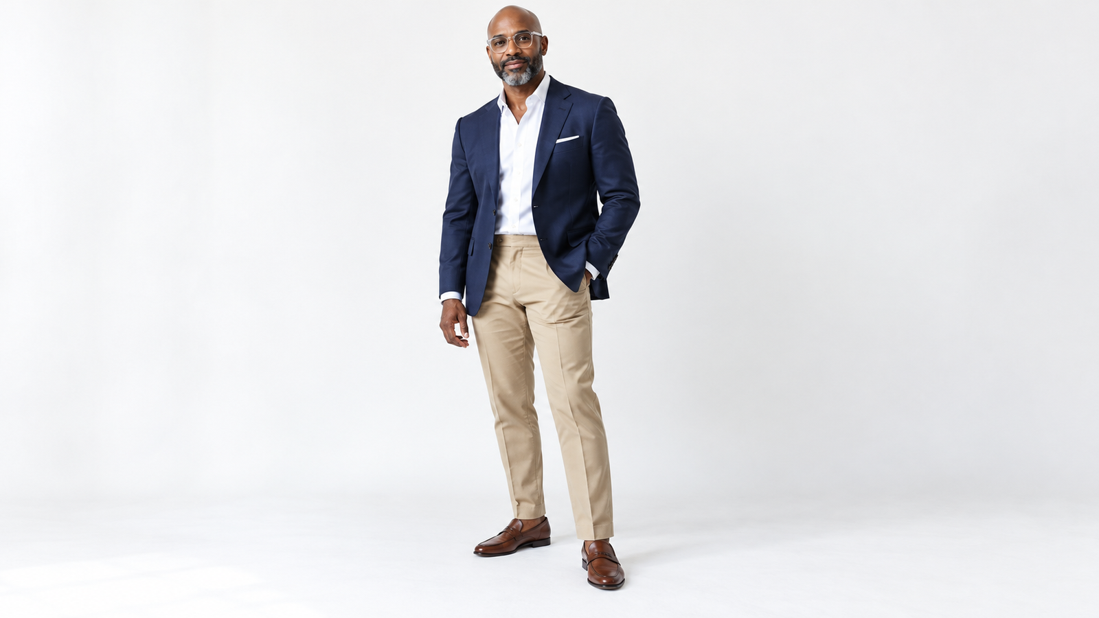 Man in a navy blazer, white shirt, khaki trousers and brown leather loafers, one look from a navy, charcoal and khaki suit palette